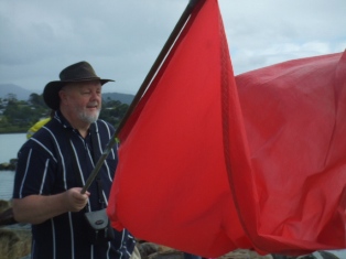Queensland Uniting Church Moderator Rev Dr David Pitman waving his flag at the blessing of the fleet