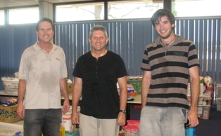 Indooroopilly members Malcolm Dunning (left), Rev. Henry Swindon and Tim Dunning at MissionAustralia with some of the parcels
