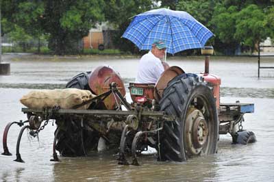 An Ingham fruit and vegetable merchant delivers potatoes in the rain. Photo by Troy Rogers and courtesy of The Townsville Bulletin