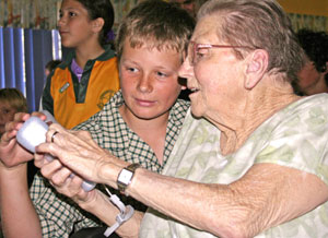 A school student teaching a Blue Care resident of Yurana Aged Care Facility, Springwood Qld, how to play Nintendo Wii ten pin bowling. Photo courtesy of Blue Care