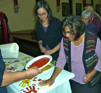 Aunty Jean Phillips places her handprint on the ‘commitment banner’ at West End. Photo courtesy of Andrew Johnson