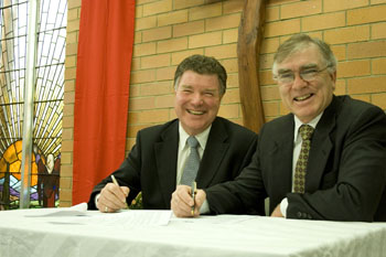 Churches of Christ in Queensland Executive Director Dean Phelan and Synod Moderator Rev Bruce Johnson sign the joint agreement. Photo by Mardi Lumsden