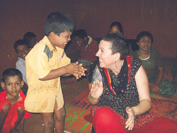Sue Pickering enjoys a game in India with a 5-year-old boy who had been abandoned because he had a disability. 