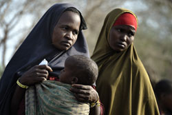 After trekking for a month across East Africa, two Somali women wait with their children to be registered in the Dadaab refugee camp in northeastern Kenya. Tens of thousands of newly arrived Somalis have swelled the population of what was already the  world’s largest refugee camp. Photo by Paul Jeffrey/ACT Alliance  