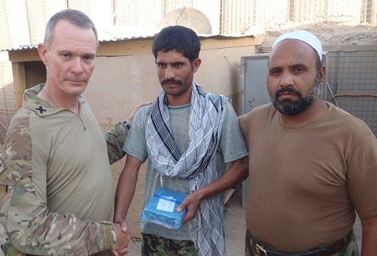 Army chaplain Rev John Saunders presents a copy of the Qur’an to a village mullah in Afghanistan. Photo: John Saunders