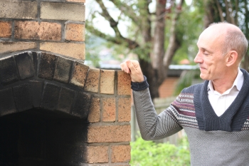 Coorparoo community garden coordinator John Loneragan with the pizza oven. Photo: Holly Jewell