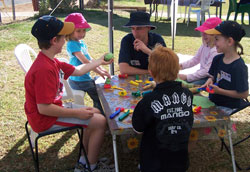 YACMU Regional Worker Andrew Bell finds a quiet spot with children at the Birdsville Races. Photo by Fay Barton