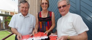 Frank Millett, Heather Donald and Rev Ray Nutley use Uniting Communications' Christmas postcards to spread the news about the Bundaberg Uniting Church Christmas services.