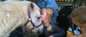 A young participant experiences horses up close at MacKay Riding for the Disabled. The photo was supplied.