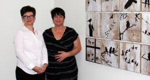 Jo Munday (left) and Adriana Leonardi (right) pictured with a piece of art made out of recycled newspapers by Cooinda mental health participants—to be displayed at the upcoming exhibition. Photo by UnitingCare Health.