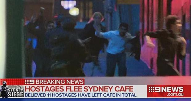 Television still of Sydney siege hostages fleeing Martin Place. Photo by Channel Nine.