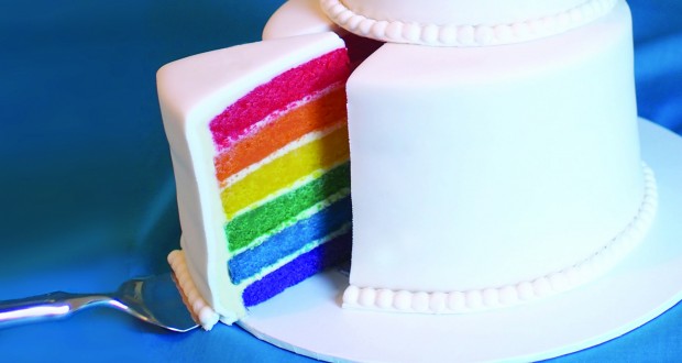 A traditional wedding cake with a rainbow layered sponge. Photo by Holly Jewell.