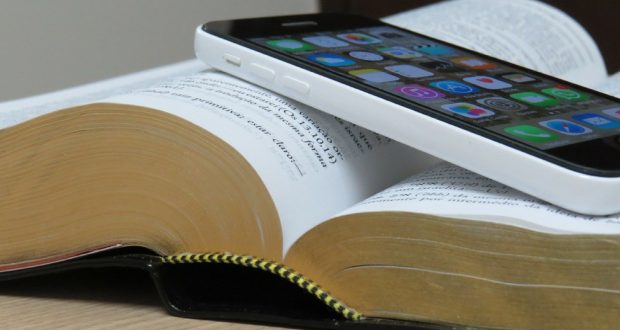 Photo of an iPhone on top of a Bible.