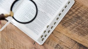 Magnifying glass over an open Bible.